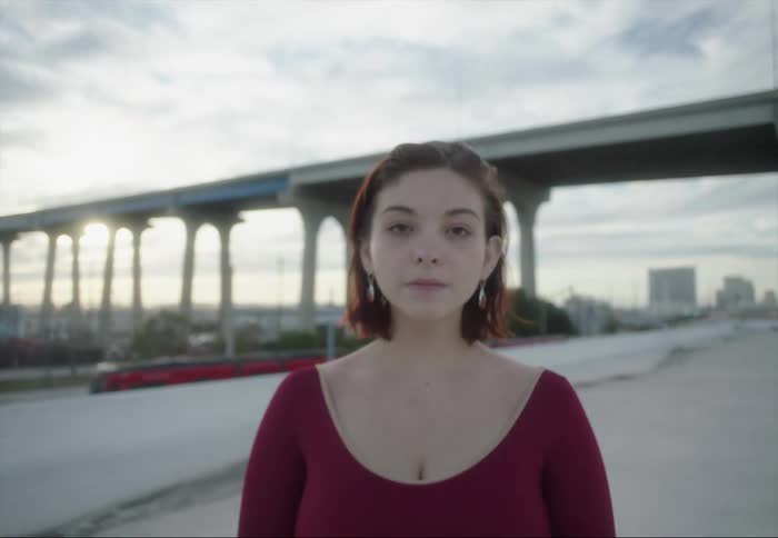 The train passes by the woman posing