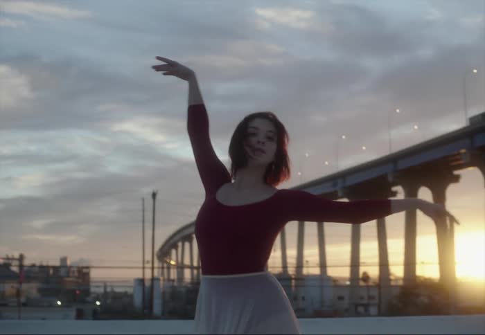 A ballerina dances outdoors on a cloudy evening