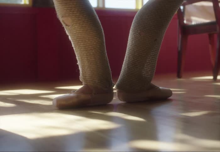 Ballerina standing on the tip of her toes in the living room