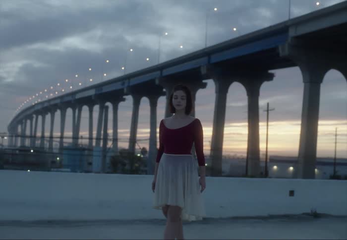 A woman is dancing by the bridge