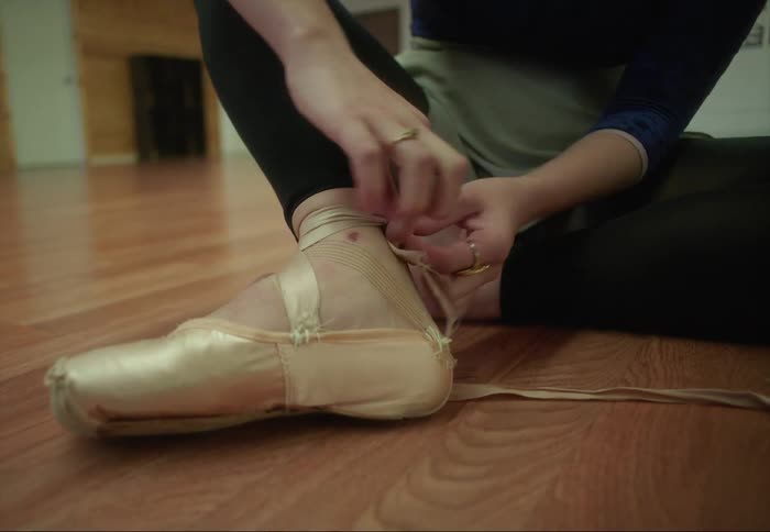 A ballerina laces her shoes