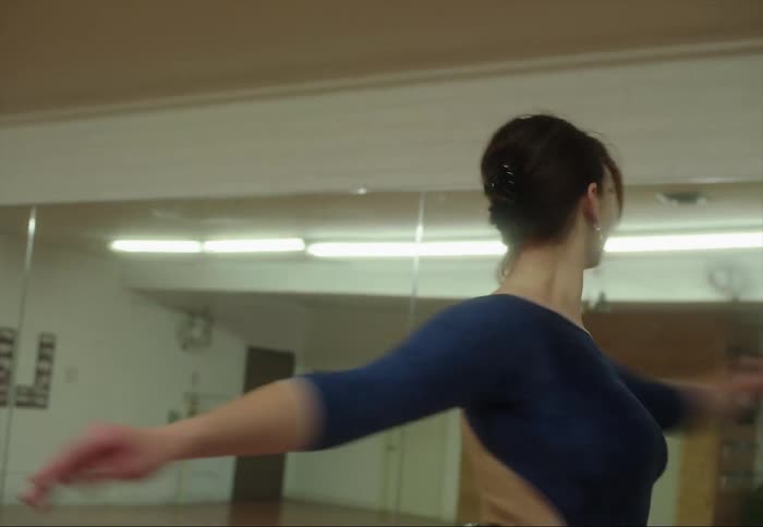 A ballerina is spinning and twirling as she dances across the room