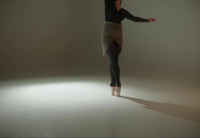 A woman is dancing ballet under flashing lights