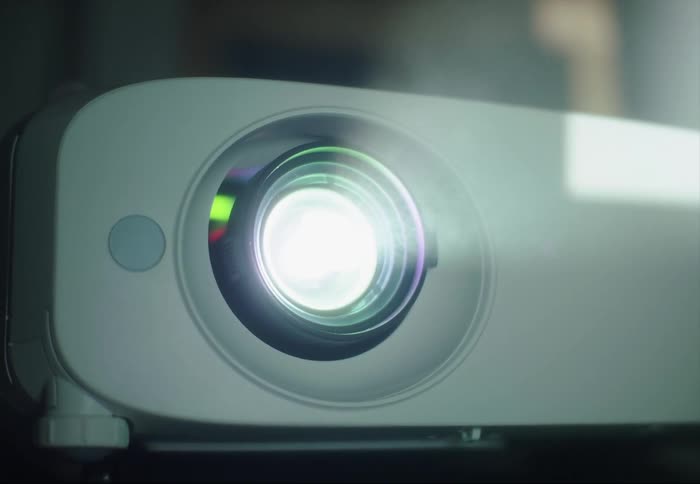 Light from projector shows foggy air as it projects image