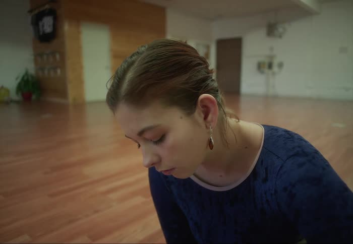 Woman sits on the floor concentrating on her feet