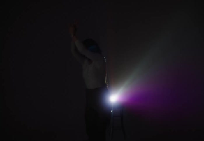 A woman performs ballet in front of a spotlight