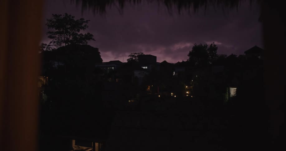 Silhouette of the skyline of a tropical town in the hills at evening