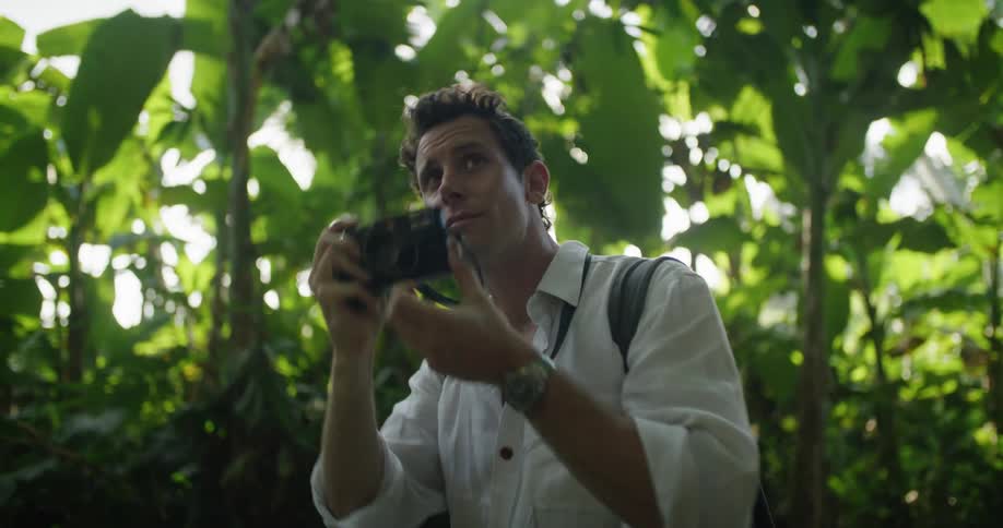 A man takes a photograph in the forest