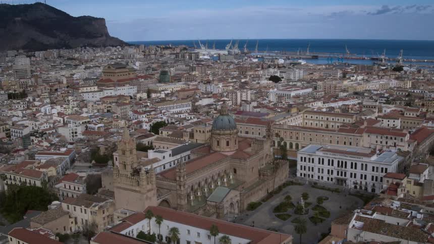 A mountain sits behind a coastal city
