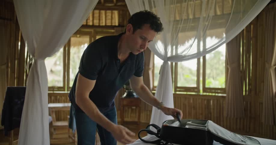 Photographer packs camera gear in hotel room made of bamboo