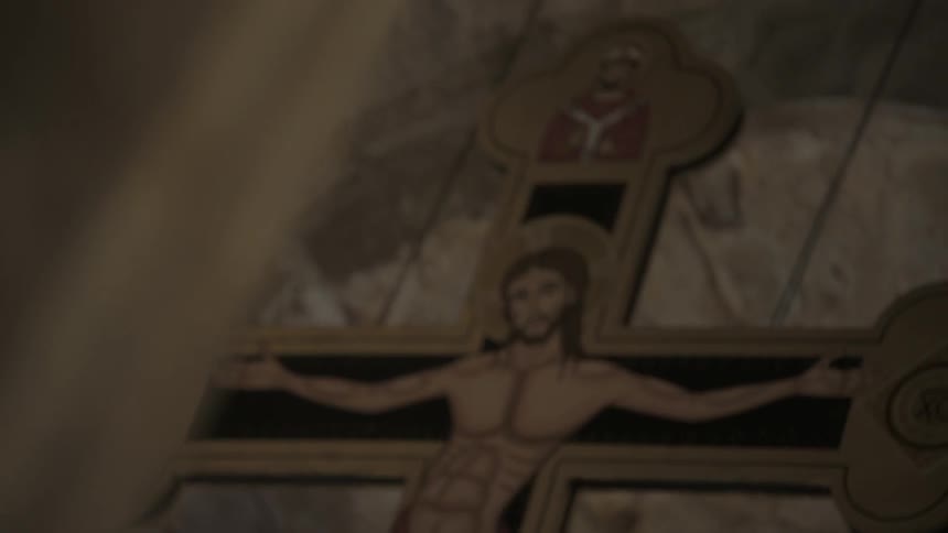 A cross is on the wall with a portrait of jesus on it