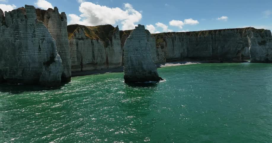 Aerial view of a cliff near the ocean coast is displayed