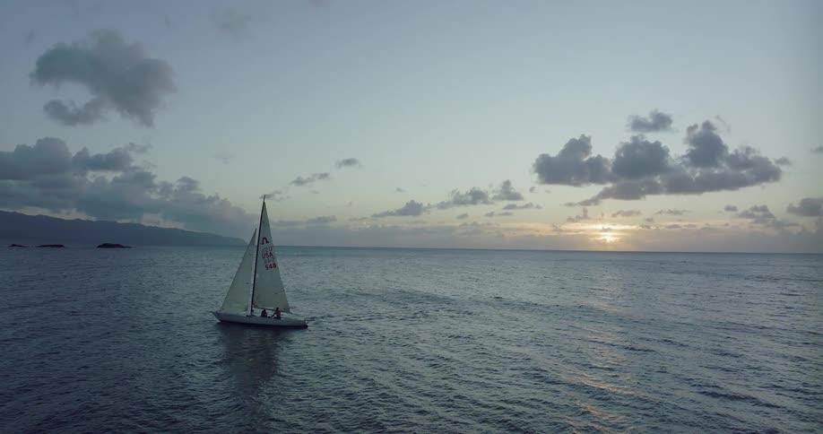 A sailboat is traveling in the ocean
