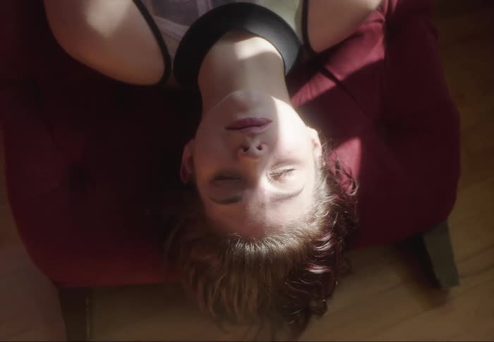 A woman lies down on a couch and rests
