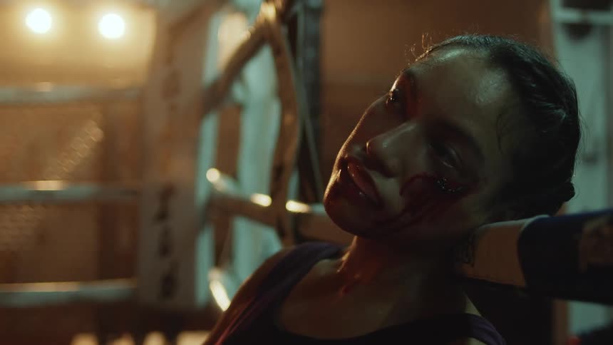 A fighter is injured and bleeding from the face