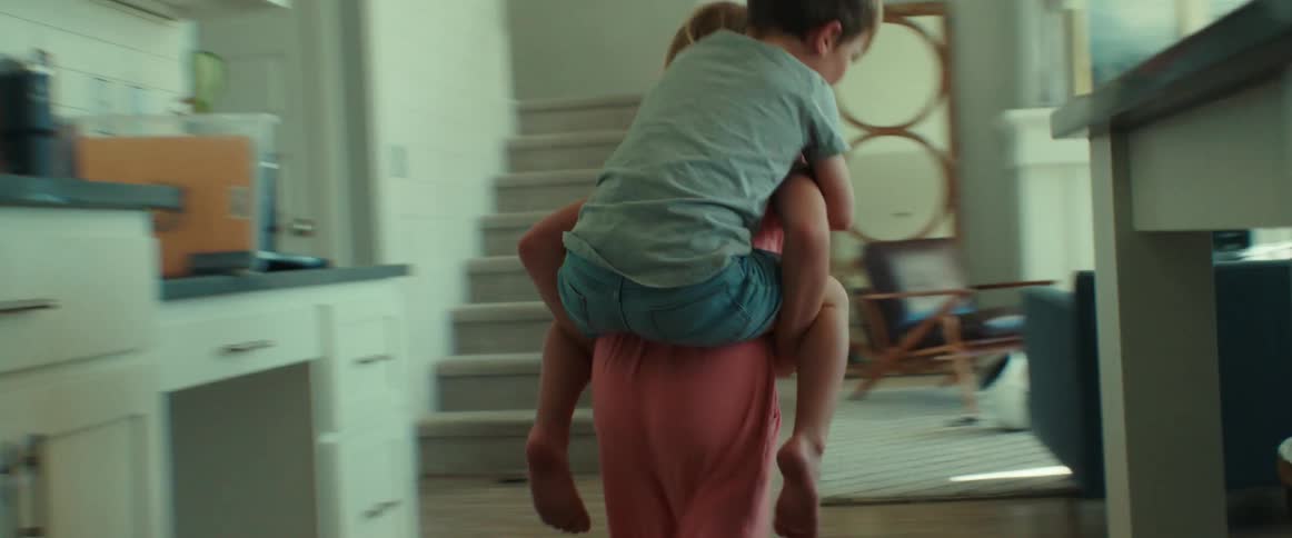A girl gives a boy a horse back ride and runs through the house