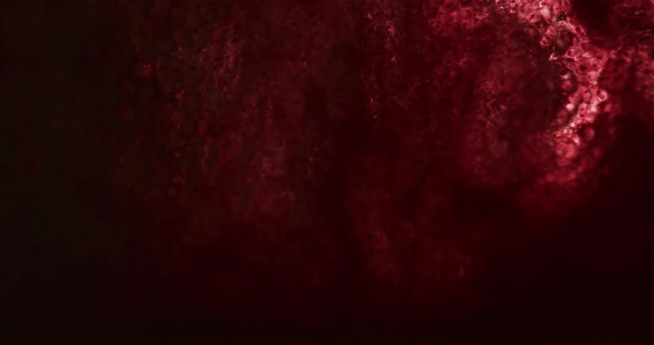 An organic red substance glows and dims in the darkness