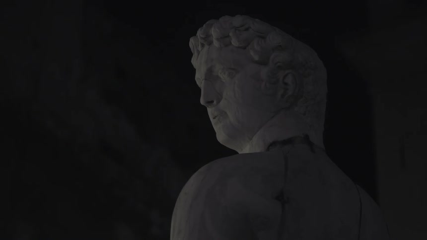 A cracked statue of a man is made from stone