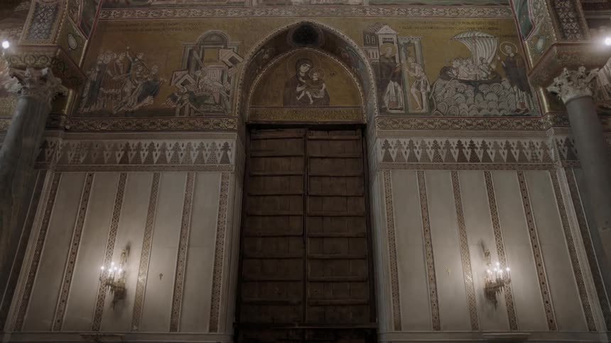 Lights shine on an elaborately painted wall and shuttered window