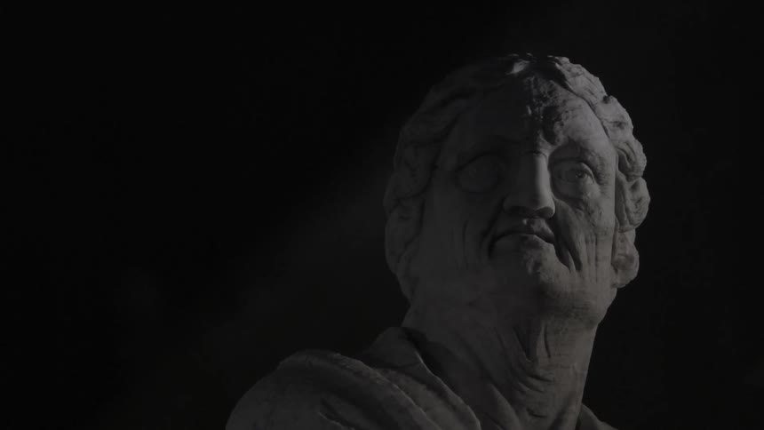 A weathered statue of a man against a dark background