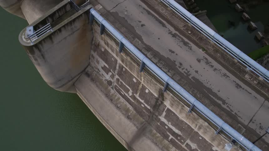 The massive concrete wall of a reservoir that forms a lake