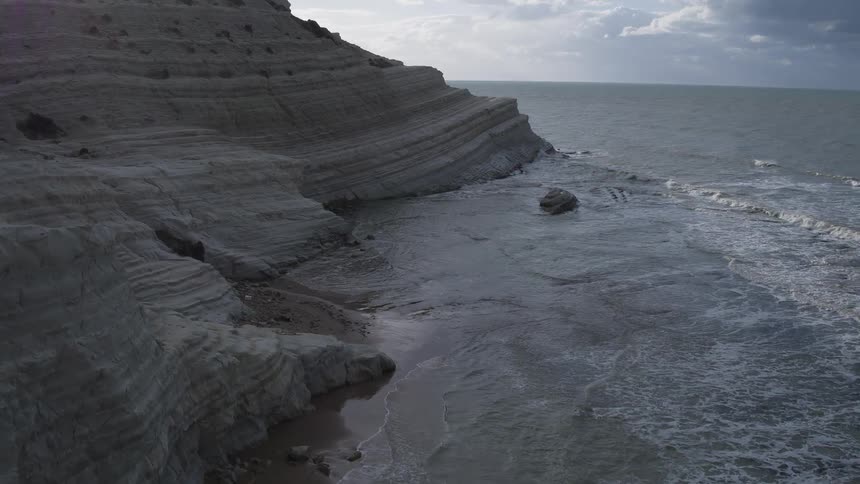 Aerial view moving along a mountain shoreline