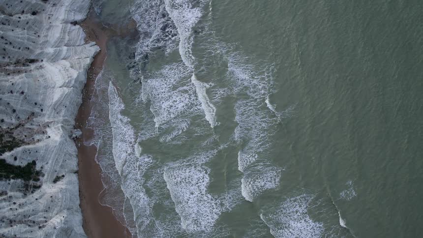 Waves crash against the shore below