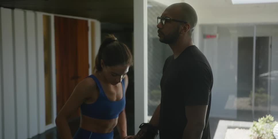 Female trainer ties the laces on the boxing gloves of her trainee
