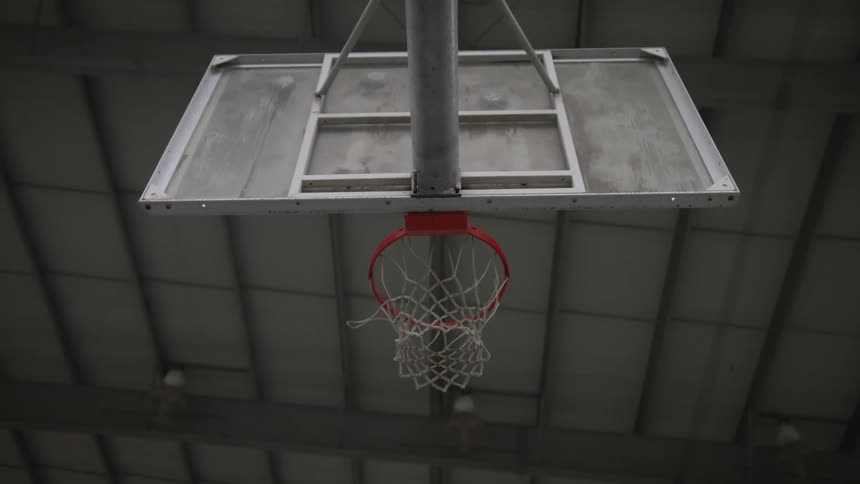 A persons hand as it shoots a basketball in to a hoop