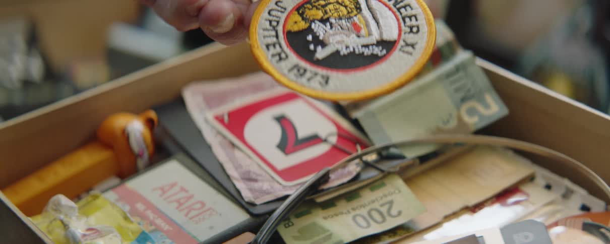 A man picks a badge up out of a drawer