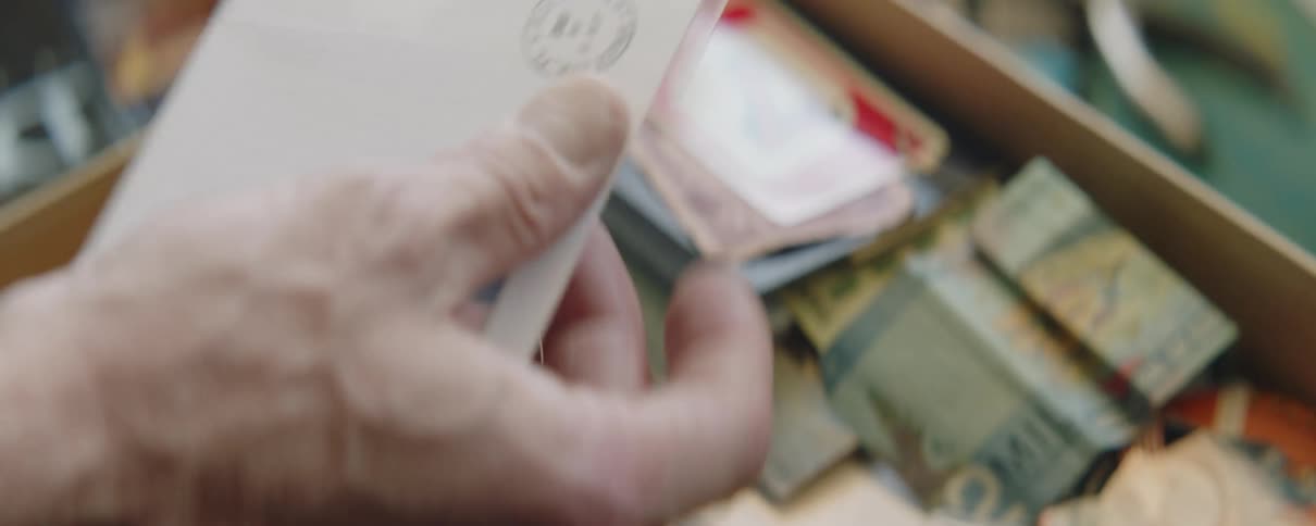 Close up of mans hands putting envelope in plastic bag