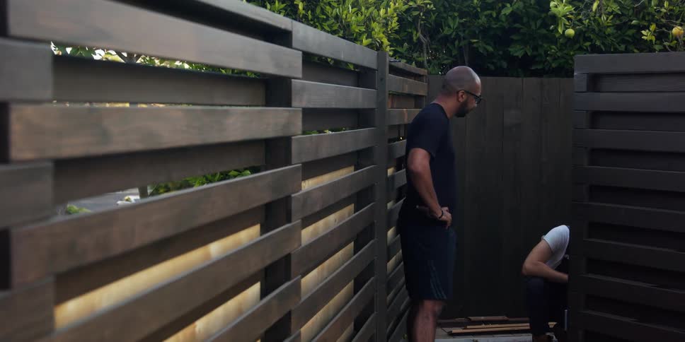 A man walks away from someone in the yard