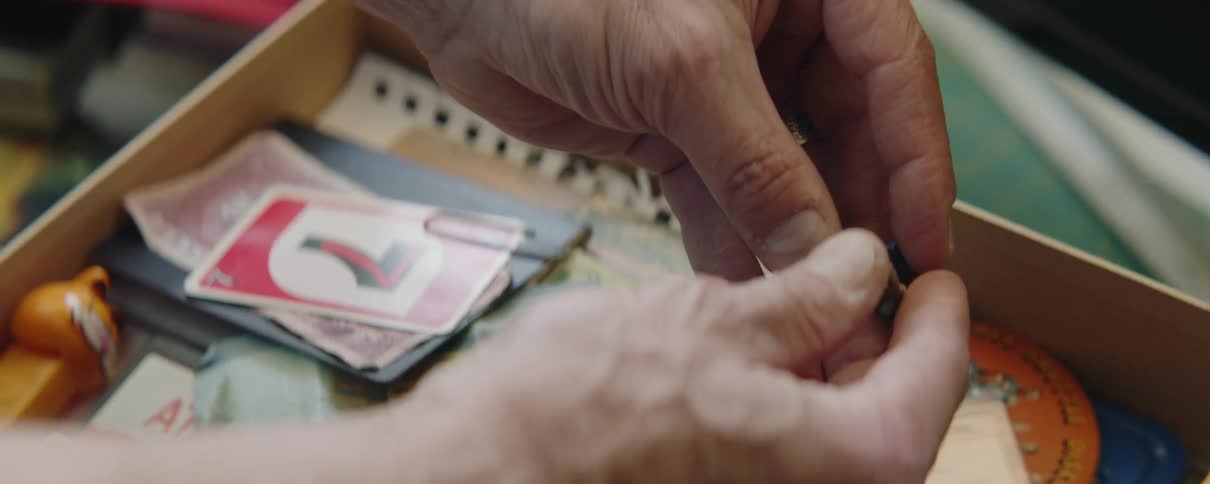 Close up of mans hands taking out old small toy from the drawer