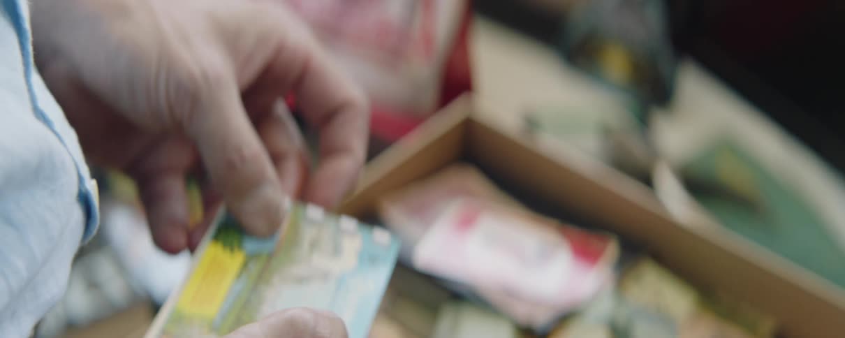 Closeup of mans hands holding a postcard of waterfall