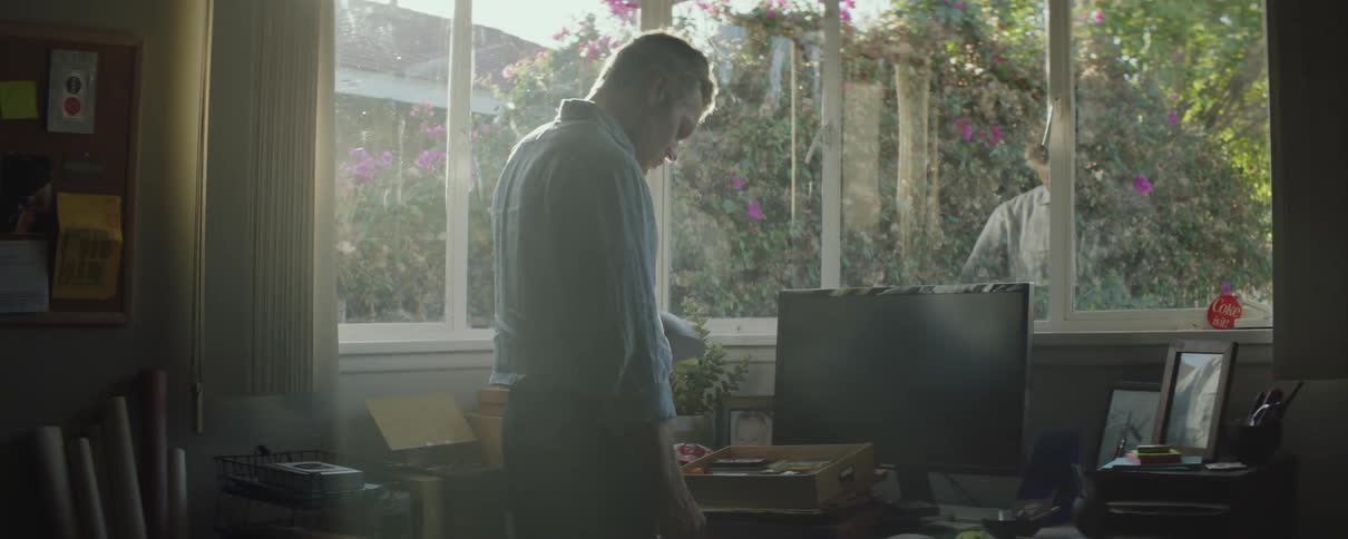 A man walks over to his desk in his home office