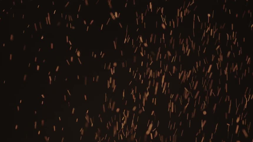 Sparks fly up into a dark sky