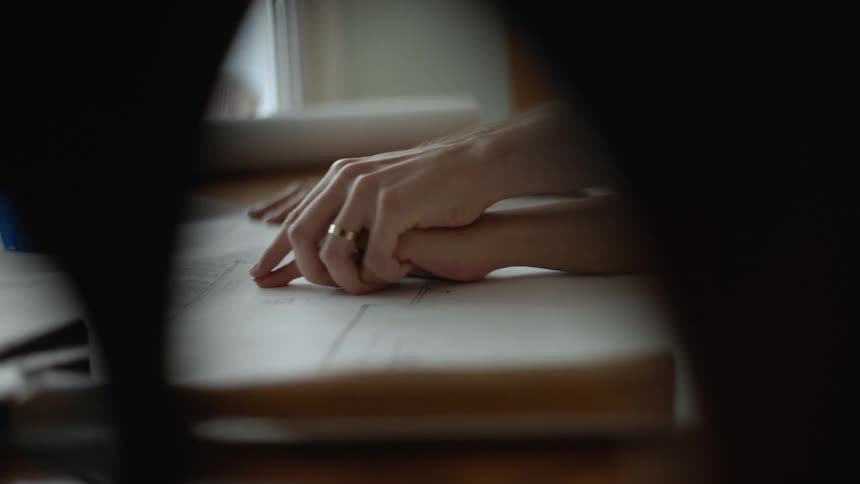 A couple holding hands and going over floor plans