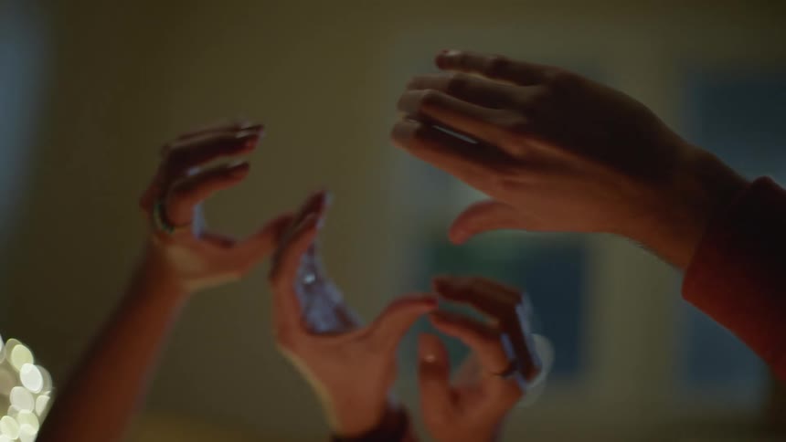 Couple resting at home playfully try to make a heart shape with their hands