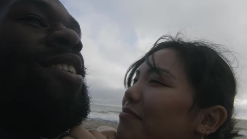 A couple talk on the beach