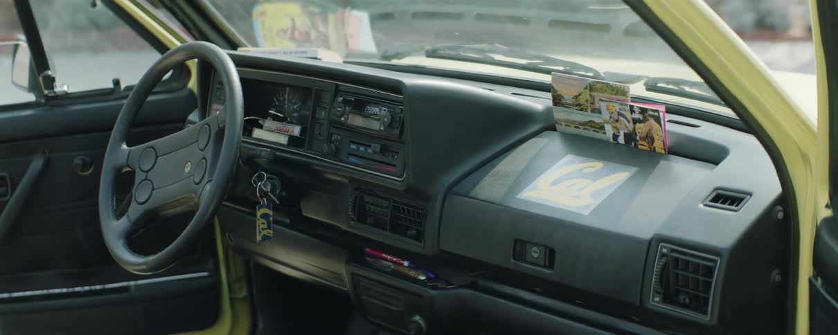 Car keys sit in ignition and brochures in the dash of an open car
