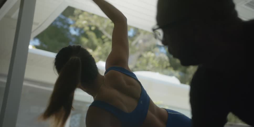 Personal trainer working with a man near the pool at home