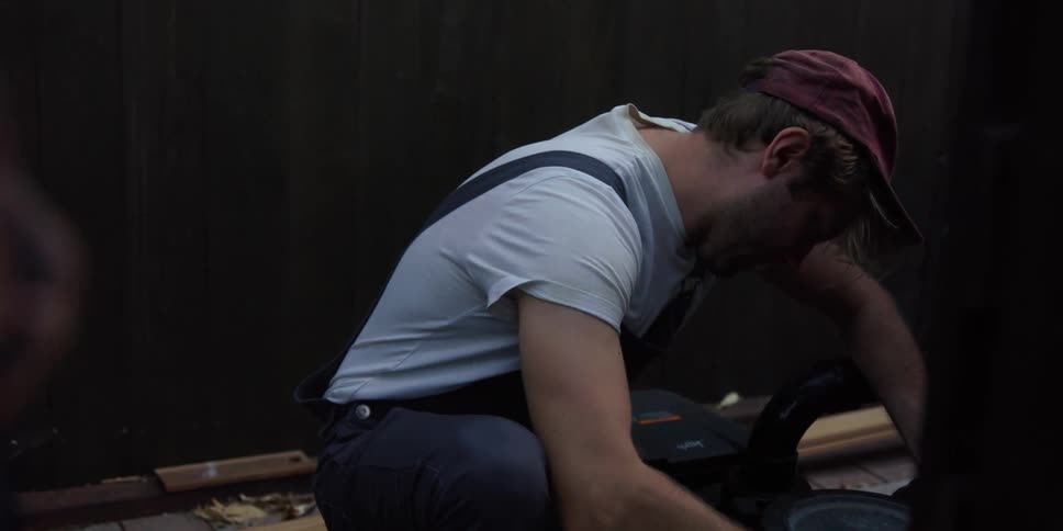A man is fixing something in a garage