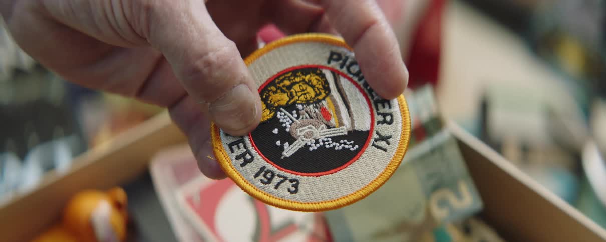 Close up of a mans hand as he holds a badge and runs his fingers over it