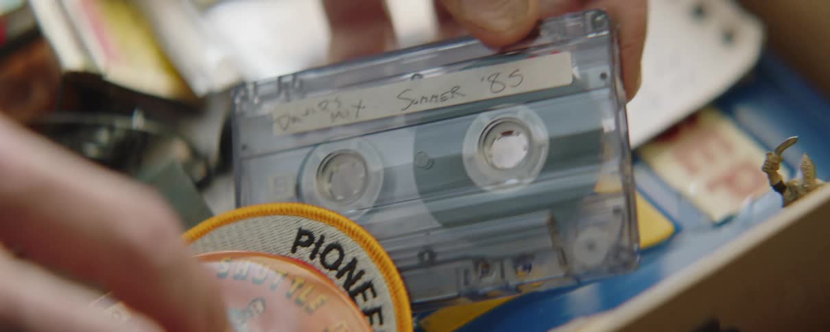 Man sorts through box of memorabilia and keepsakes