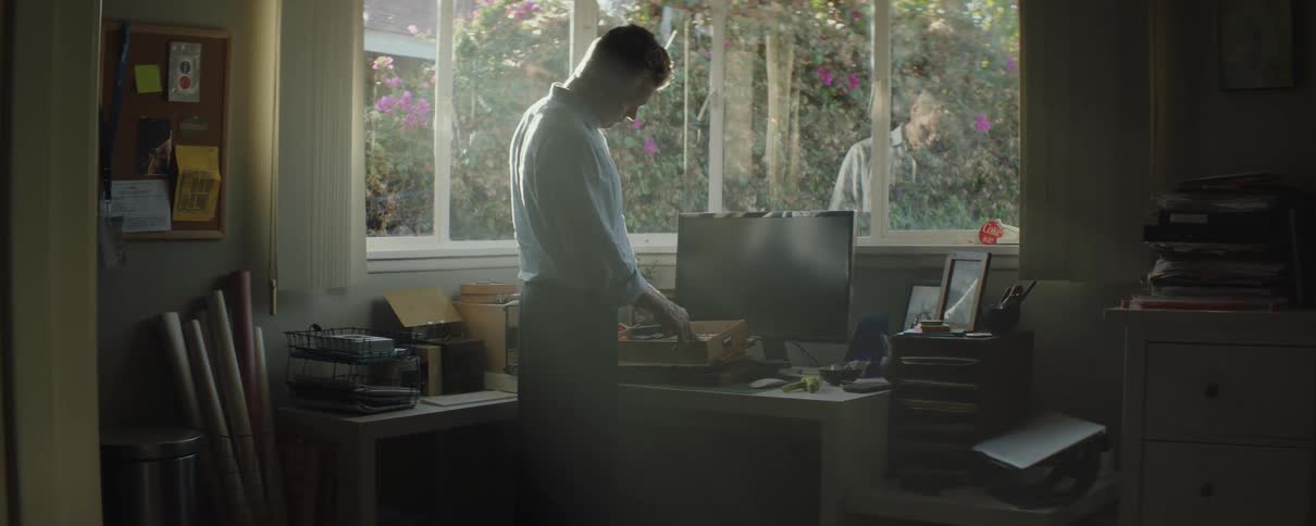 A man organizes files while standing in his home office