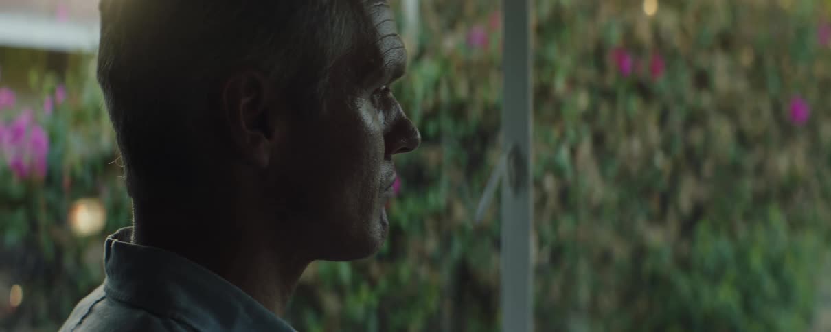 Man stands on house porch staring toward car in driveway