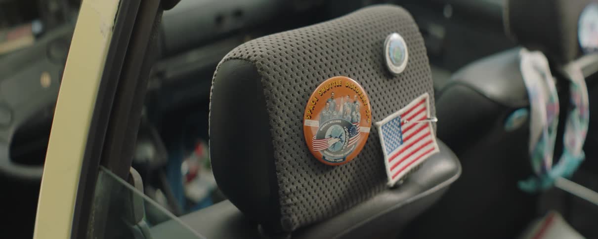 Pins and emblems decorate the headrest of a messy vehicle