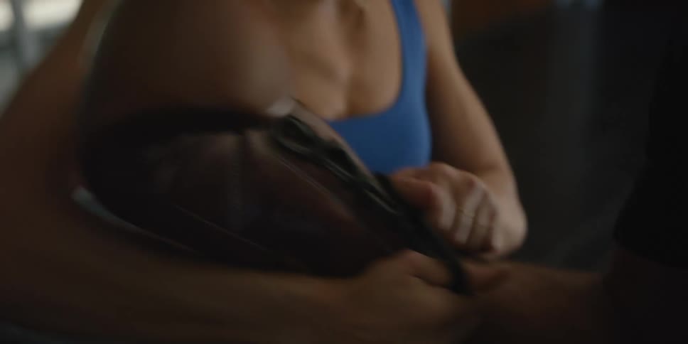 Female personal trainer helps student to firmly put a boxing glove on his right hand
