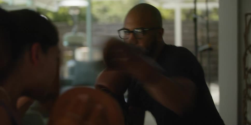 Man sparring with a female boxing trainer on the backyard at daytime