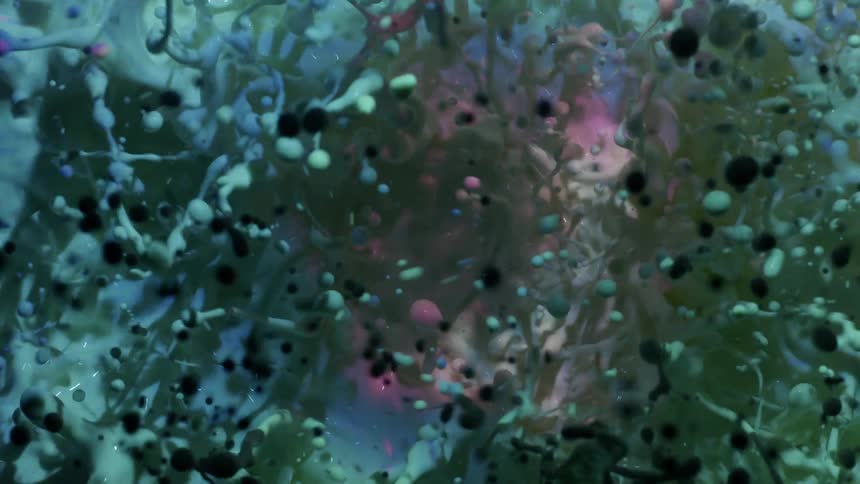 Purple and pink pastel colors reflect in liquid and black and green balls float around